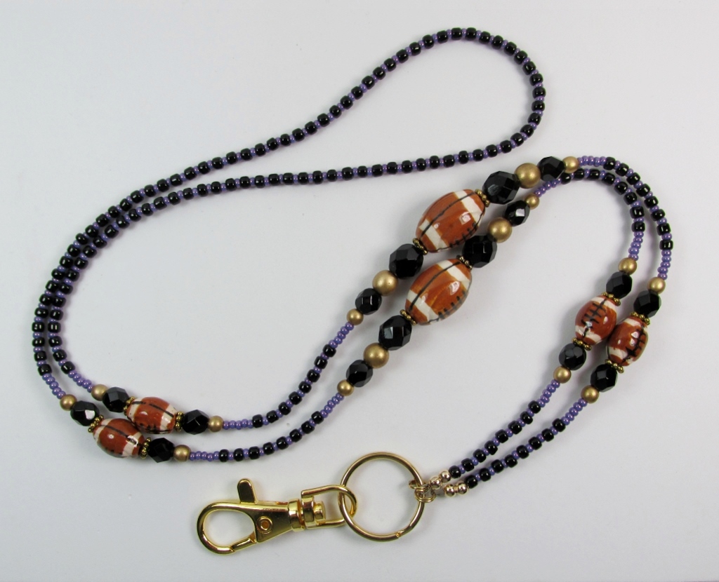 Purple, black and 
gold beaded lanyard with ceramic football beads